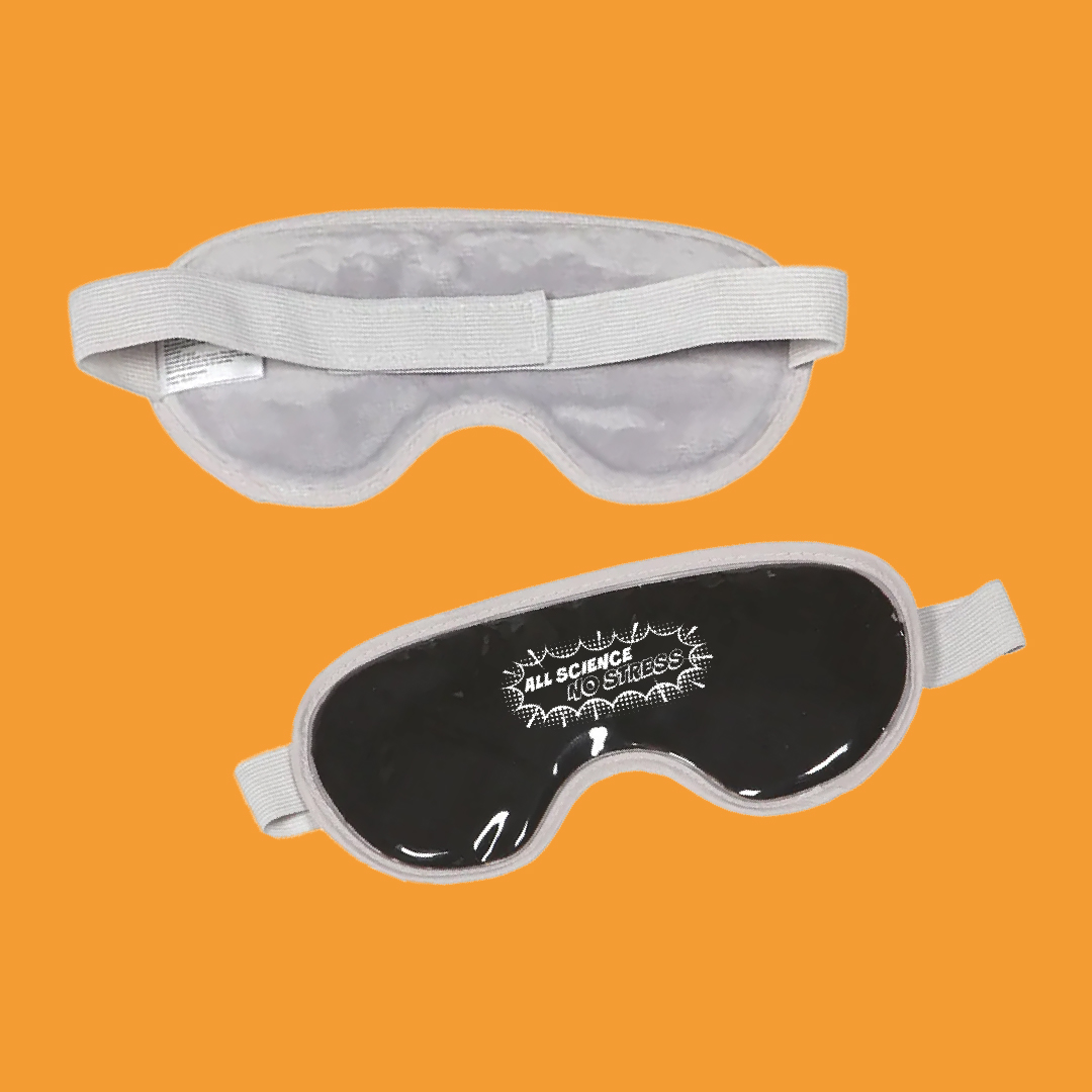 A black and grey fabric eye mask with “all science no stress” printed on the front pictured on an orange background.