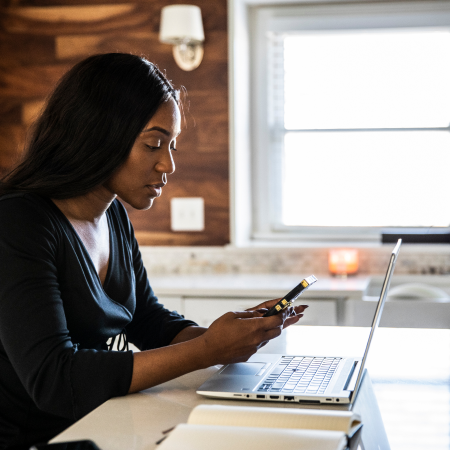 Woman in office looking at phone | Pfizer clinical trials