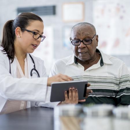 Nurse showing man tablet | Pfizer clinical trials